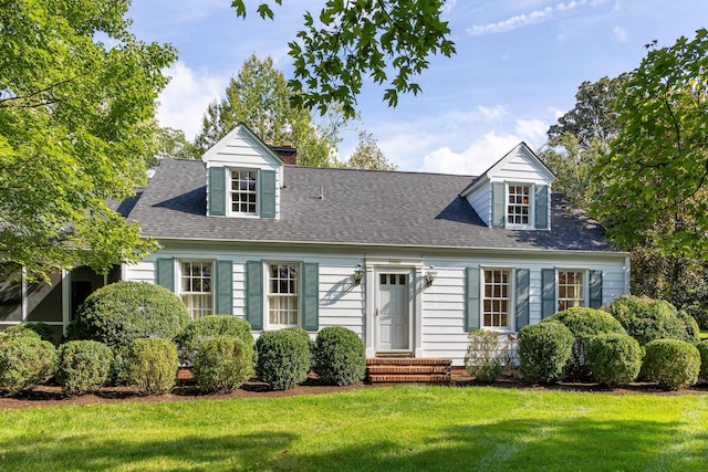 cape cod home with a front lawn