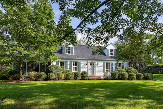 new england style home with a sunroom and a front lawn