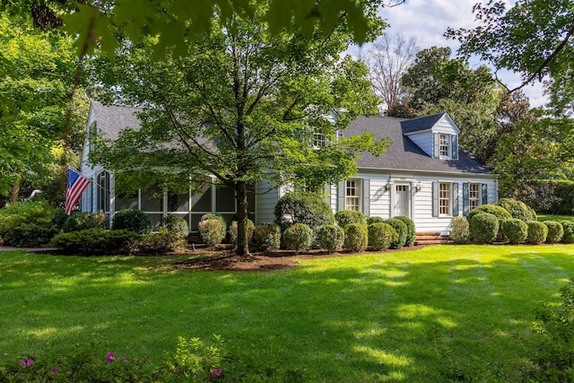 cape cod-style house featuring a front yard