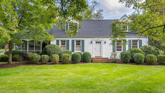 new england style home with a sunroom and a front lawn