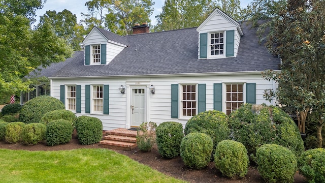 cape cod house with a front lawn