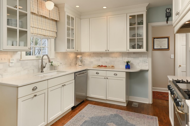 kitchen with appliances with stainless steel finishes, backsplash, sink, and dark hardwood / wood-style floors