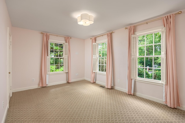 carpeted empty room featuring plenty of natural light