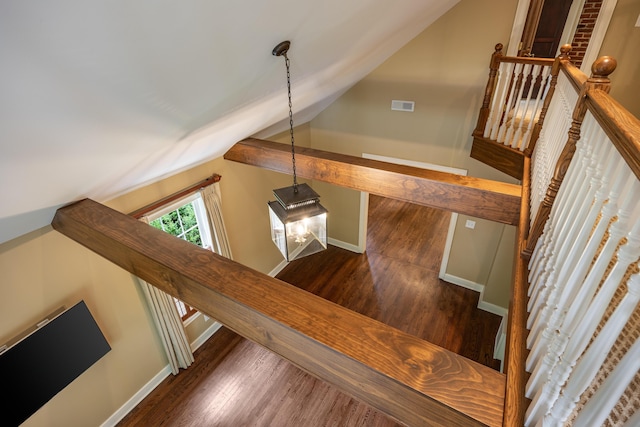 stairway with wood-type flooring and vaulted ceiling