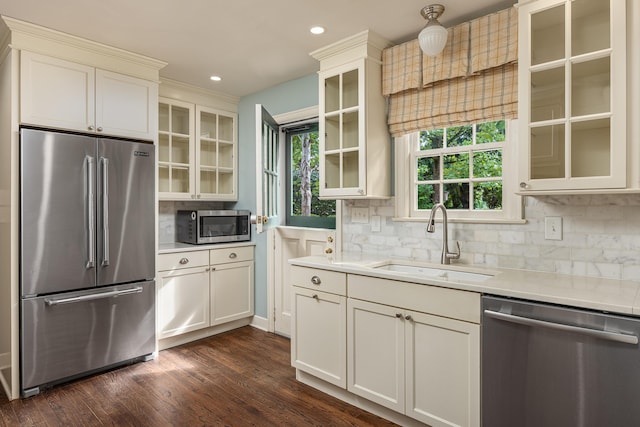 kitchen featuring stainless steel appliances, dark hardwood / wood-style floors, sink, and decorative backsplash