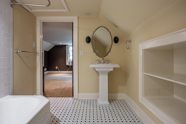 bathroom with vaulted ceiling and a tub to relax in