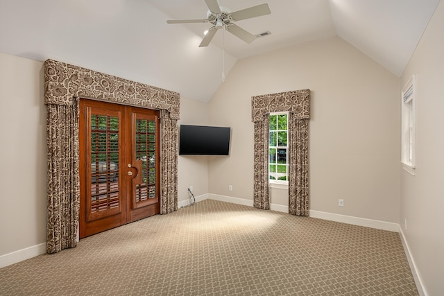 carpeted spare room featuring lofted ceiling, ceiling fan, and french doors