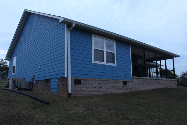 view of side of property featuring a yard and central AC unit