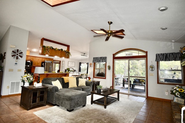 living room with high vaulted ceiling, ceiling fan, and light tile patterned floors