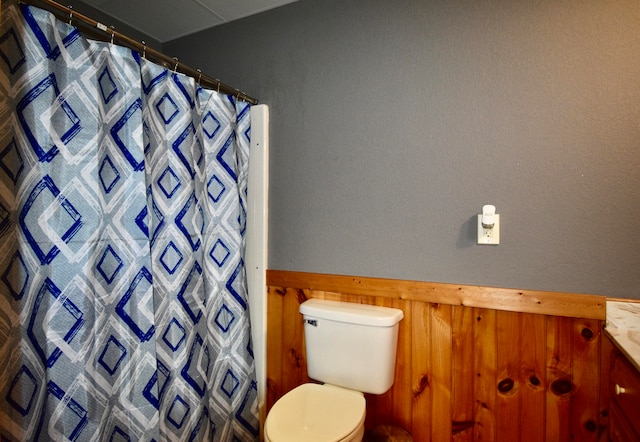 bathroom with walk in shower, vanity, and toilet