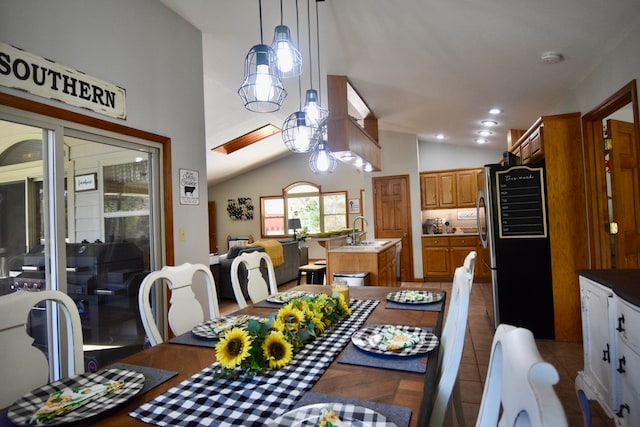 dining area featuring tile patterned flooring, vaulted ceiling, and sink