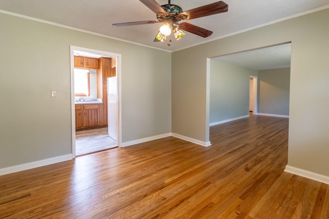 empty room featuring ceiling fan, crown molding, and hardwood / wood-style floors