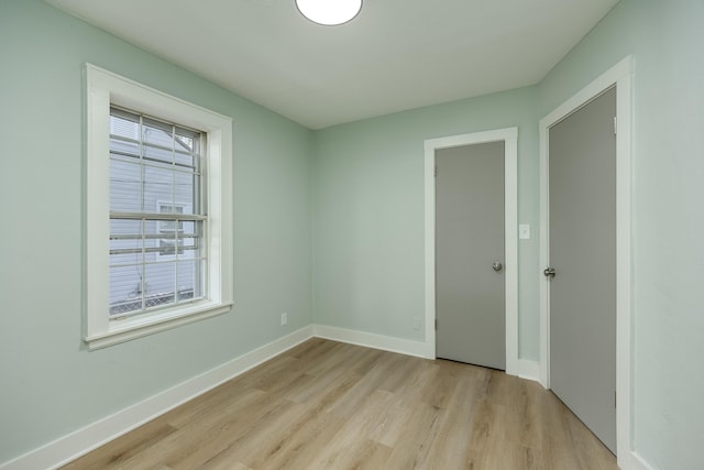 spare room featuring a healthy amount of sunlight and light wood-type flooring