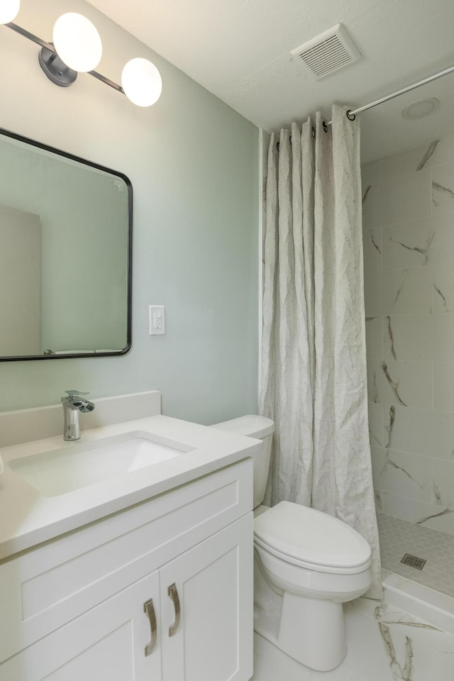 bathroom featuring toilet, vanity, and walk in shower