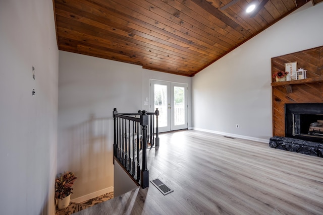 living room with french doors, lofted ceiling, light hardwood / wood-style flooring, and wooden ceiling