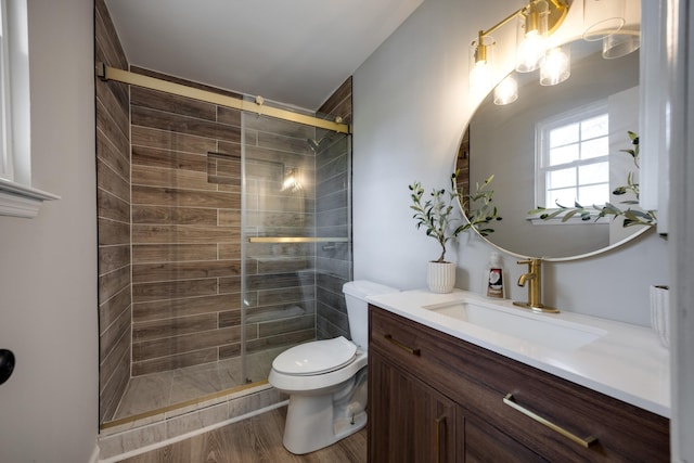 bathroom featuring hardwood / wood-style floors, vanity, toilet, and walk in shower