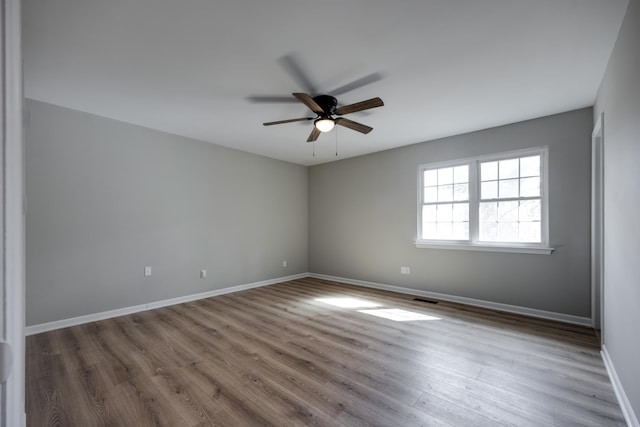 empty room with ceiling fan and wood-type flooring