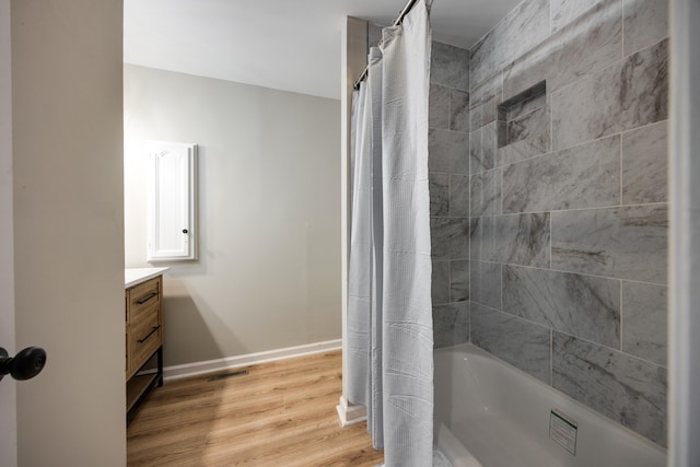 bathroom with shower / bathtub combination with curtain, vanity, and wood-type flooring