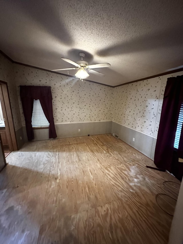 unfurnished room with light wood-type flooring, a textured ceiling, and ceiling fan