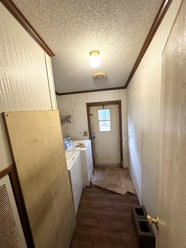 laundry room with crown molding, dark wood-type flooring, and washing machine and dryer