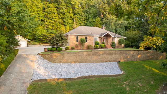 view of front of home with a front yard, a garage, and an outdoor structure