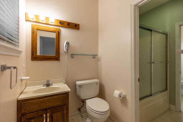 full bathroom featuring shower / bath combination with glass door, vanity, and toilet