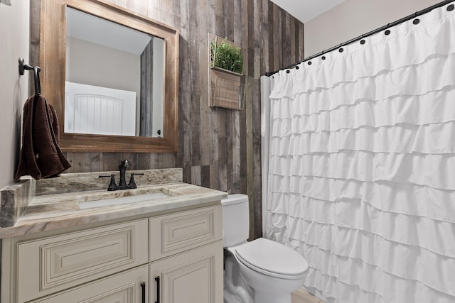 bathroom featuring walk in shower, vanity, wood walls, and toilet