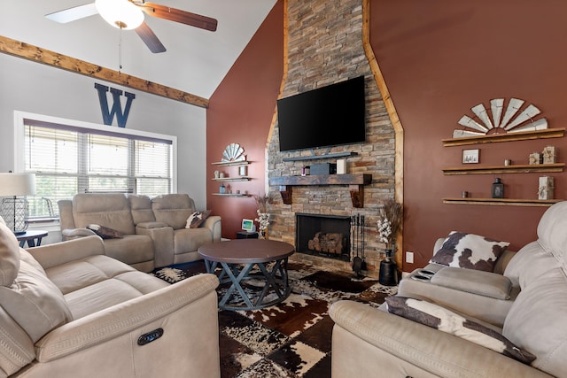 living room featuring ceiling fan, a stone fireplace, and high vaulted ceiling