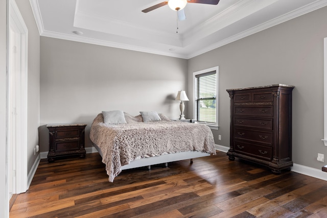 bedroom featuring a tray ceiling, ceiling fan, dark wood-type flooring, and crown molding