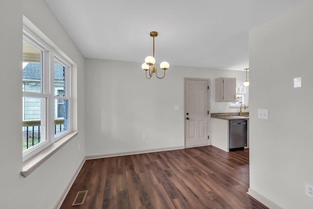 unfurnished dining area featuring an inviting chandelier and dark hardwood / wood-style floors