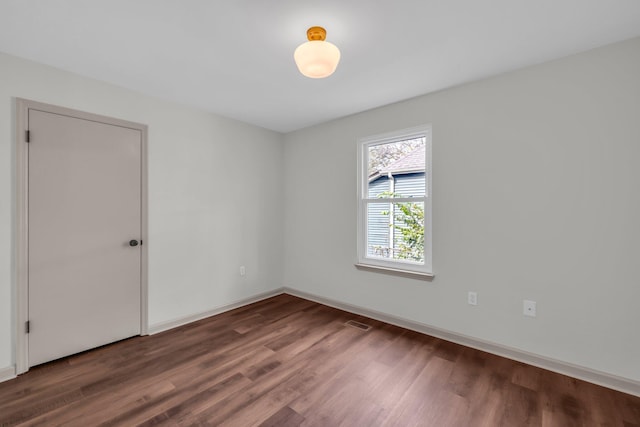 unfurnished room with dark hardwood / wood-style flooring