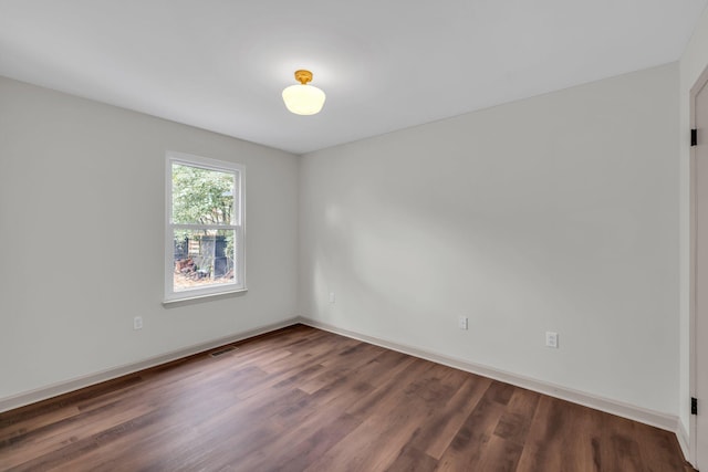 spare room with dark hardwood / wood-style flooring