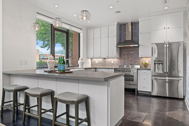 kitchen featuring white cabinets, wall chimney exhaust hood, kitchen peninsula, and stainless steel appliances