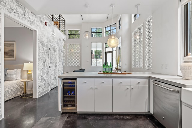 kitchen featuring white cabinetry, wine cooler, stainless steel dishwasher, kitchen peninsula, and pendant lighting