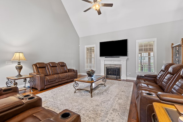 living room with hardwood / wood-style floors, ceiling fan, and high vaulted ceiling