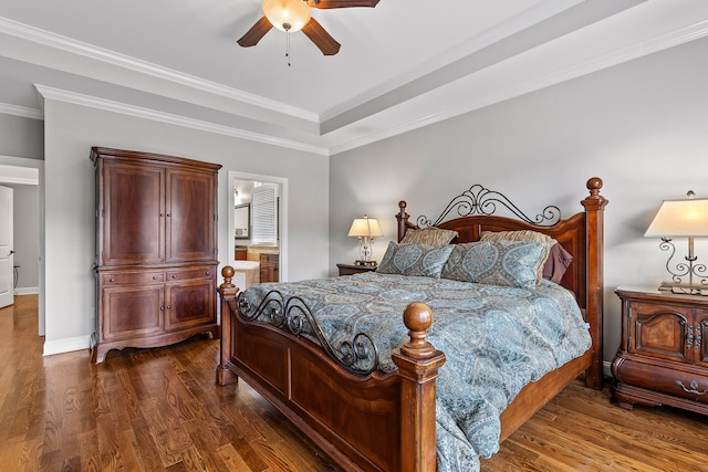 bedroom featuring dark wood-type flooring, ensuite bath, ceiling fan, and ornamental molding