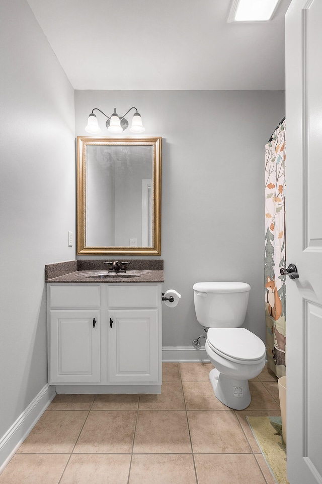 bathroom featuring tile patterned floors, vanity, and toilet