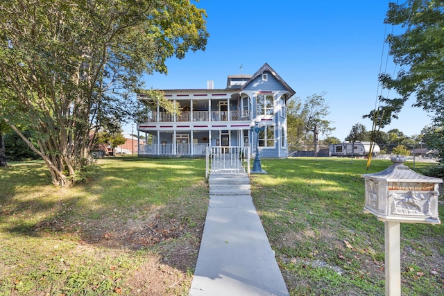 view of front of house featuring a balcony and a front yard