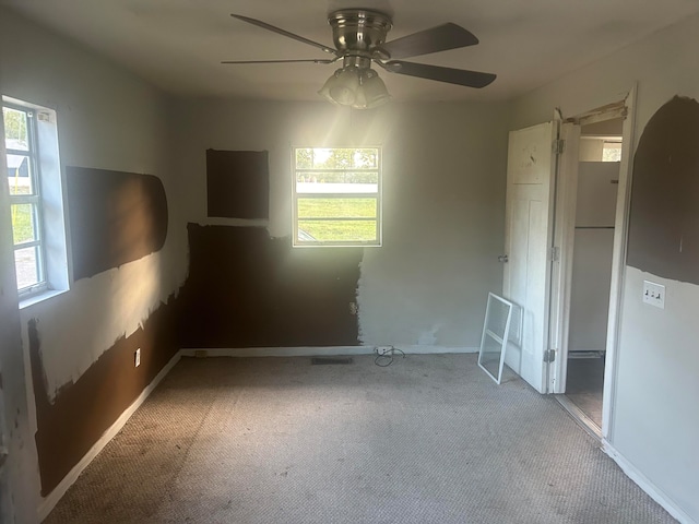 spare room with ceiling fan and light colored carpet