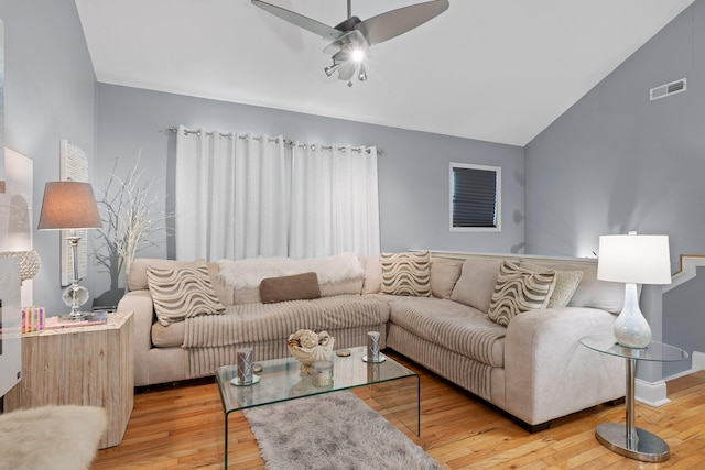 living room featuring ceiling fan, hardwood / wood-style flooring, and vaulted ceiling