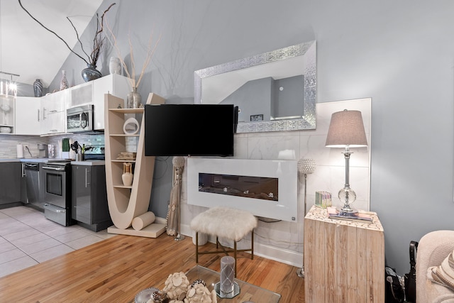 living room featuring vaulted ceiling and light hardwood / wood-style flooring