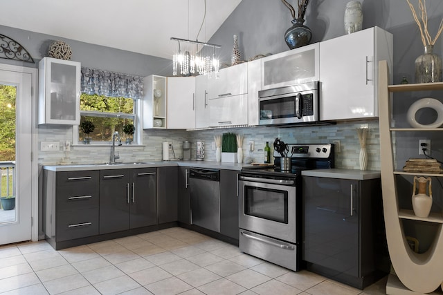 kitchen with appliances with stainless steel finishes, plenty of natural light, and white cabinets