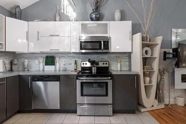 kitchen featuring appliances with stainless steel finishes, backsplash, white cabinetry, and light tile patterned floors