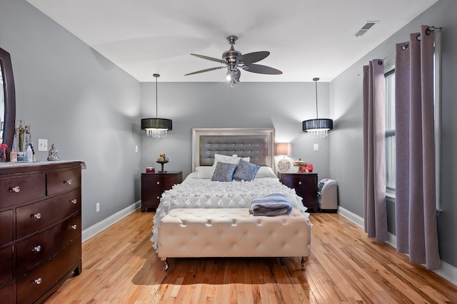 bedroom with multiple windows, light hardwood / wood-style floors, and ceiling fan