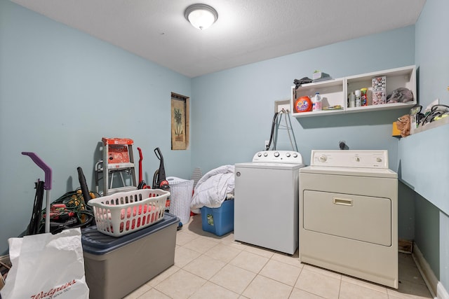 clothes washing area featuring a textured ceiling, independent washer and dryer, and light tile patterned flooring