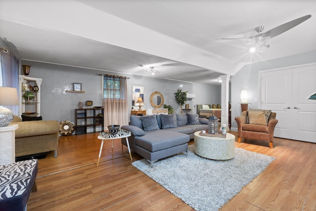 living room featuring light hardwood / wood-style floors, decorative columns, and ceiling fan