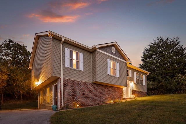 property exterior at dusk with a lawn