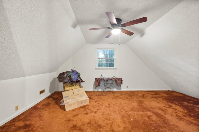 additional living space with lofted ceiling, ceiling fan, carpet, and a textured ceiling