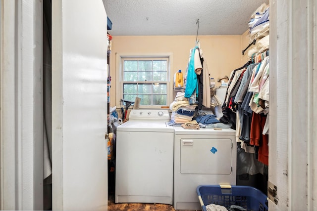 clothes washing area featuring washing machine and clothes dryer and a textured ceiling