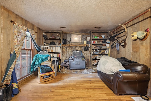 living room featuring hardwood / wood-style floors, wooden walls, and a textured ceiling